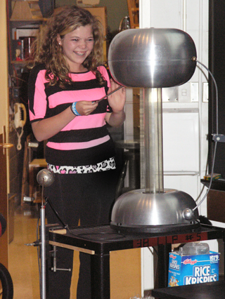 Student experiences effect of Van de Graaff generator.